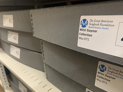 Gray archival oxes titled &quot;Mitzi Gaynor Collection&quot; sit on the shelves of the Songbook Library &amp; Archives.