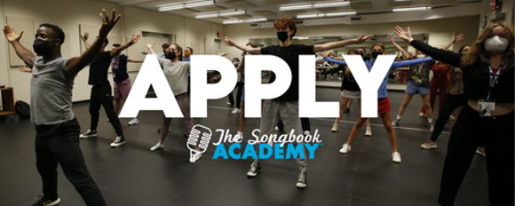 Apply Songbook Academy. A group of people dance in a room.