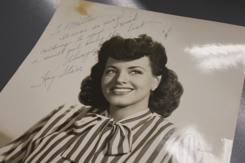 Kay Starr, a white and Native American singer, looks off to the left and smiles. She is a stunning woman with bright eyes, a 40s hairstyle and striped blouse.