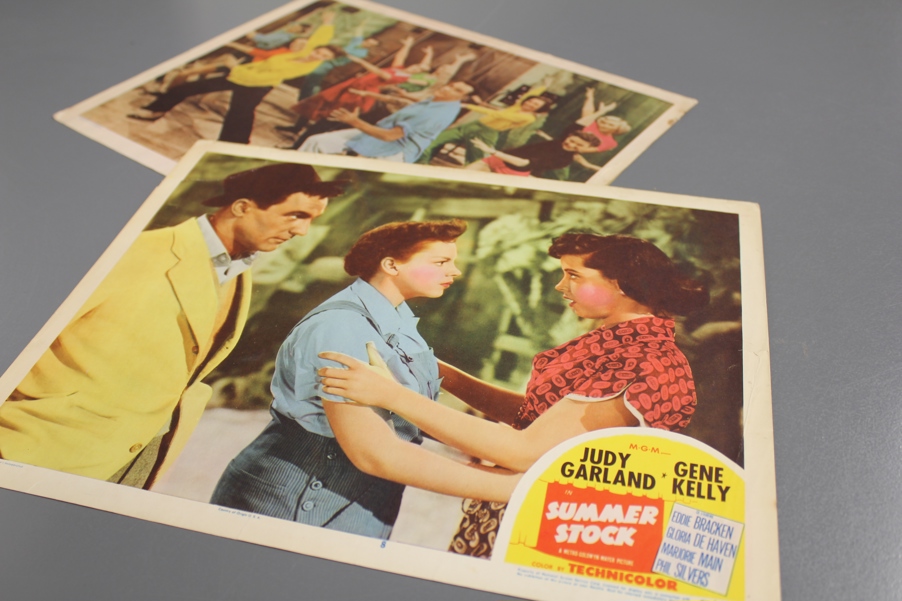 Judy Garland and Gene Kelly dance and act in a still shot from the movie "Summer Stock". They are dressed in 50s clothes in pastels.