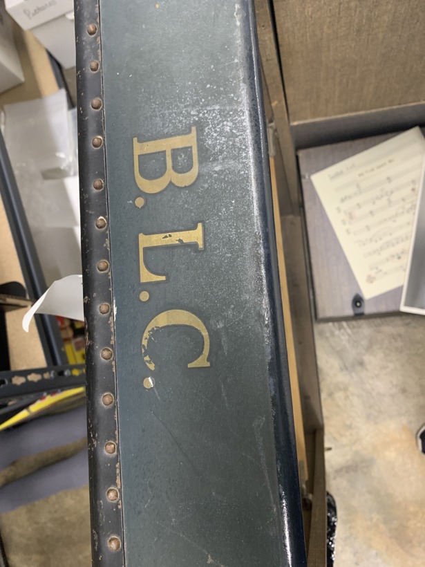 The initials B.L.C. are printed on a dark green traveling trunk.