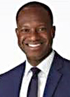 Headshot of a man wearing a dark suit, smiling