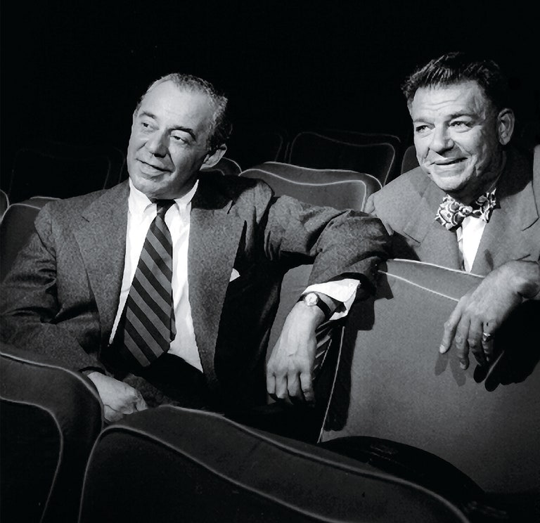 Richard Rodgers and Oscar Hammerstein sit in theatre seats.