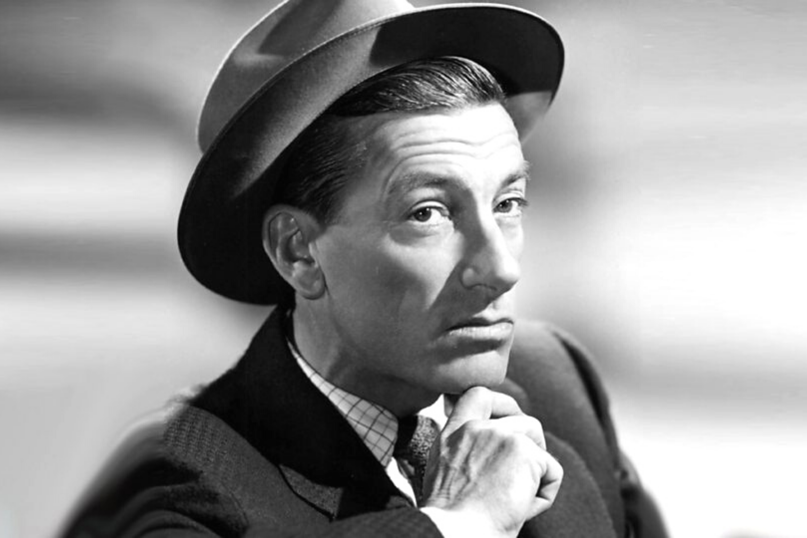 Hoagy Carmichael poses with his hand on his chin, an expressionless face, and a wide-brimmed hat.