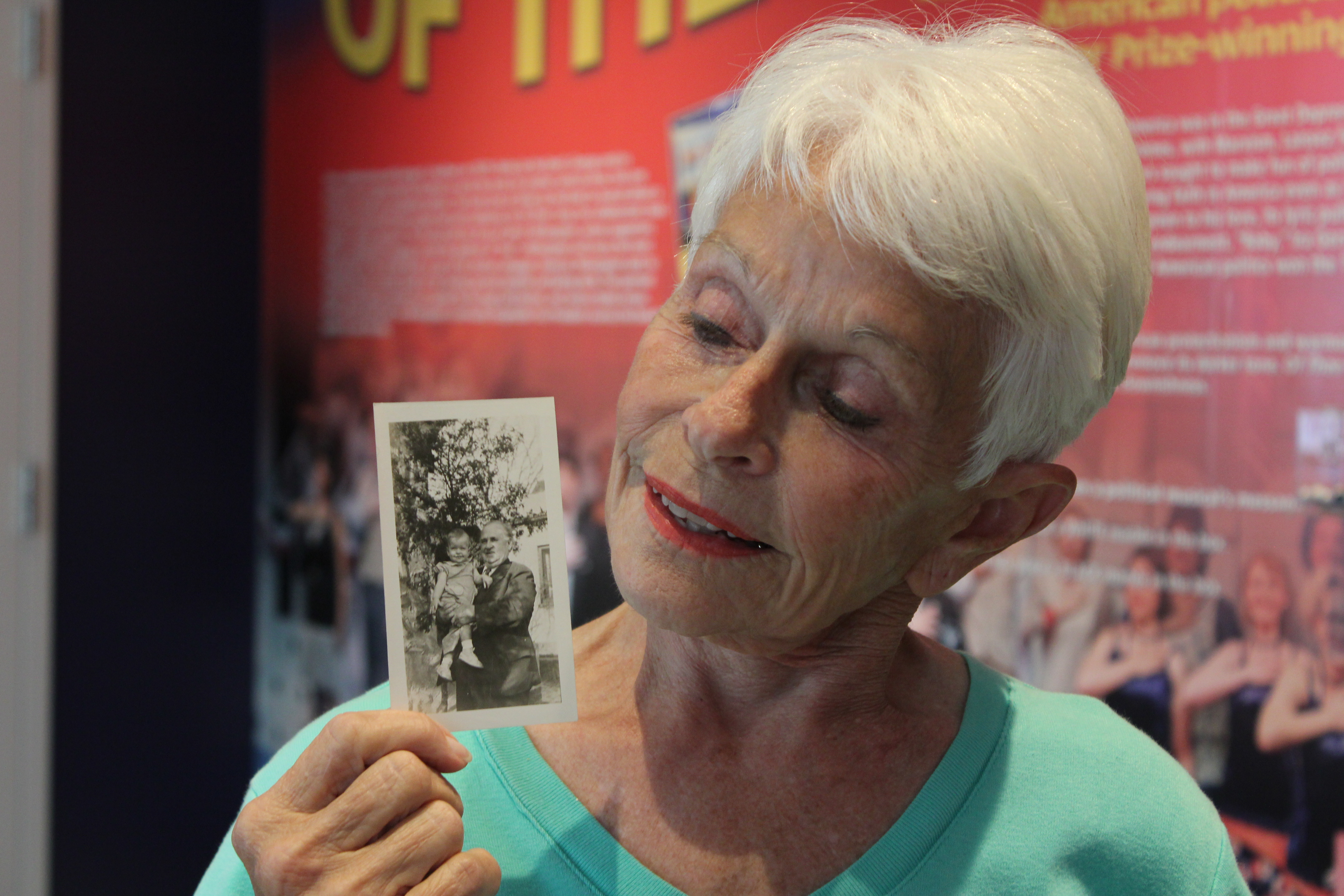 Marilyn looks down at a photo from the 1940s of her grandfather holding her as a baby.