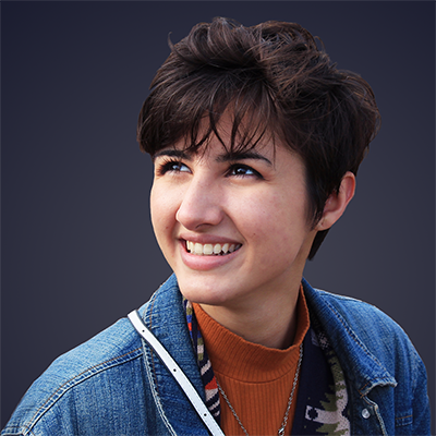 A young woman in a denim jacket smiles for a headshot