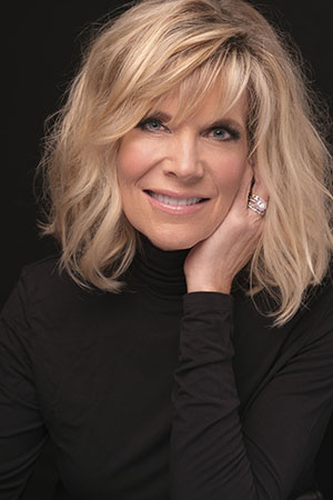 Headshot of singer Debby Boone, sporting blonde hair and a black sweater.