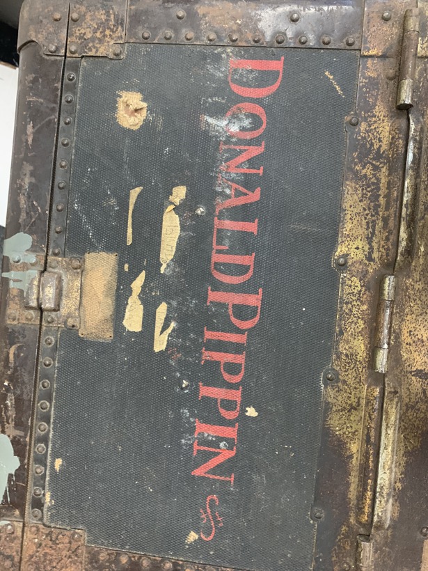 Donald Pippin's name is stamped in red on the top of a well-used traveling trunk.