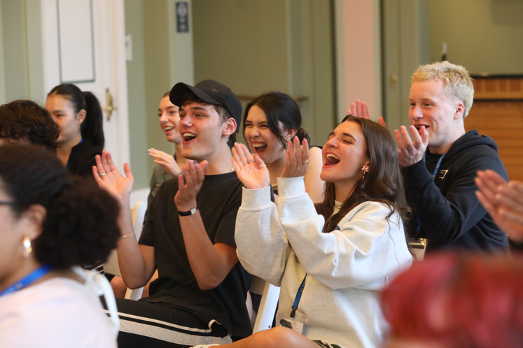 A group of high school students clap.