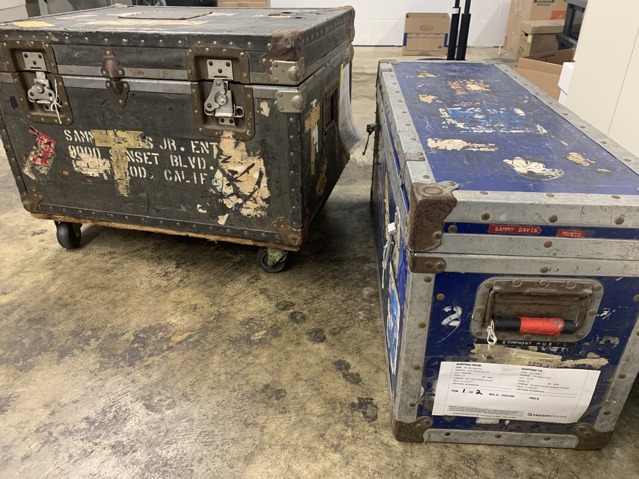 Black and blue traveling trunks that belonged to Sammy Davis Jr. with various stickers and hand stamped words/