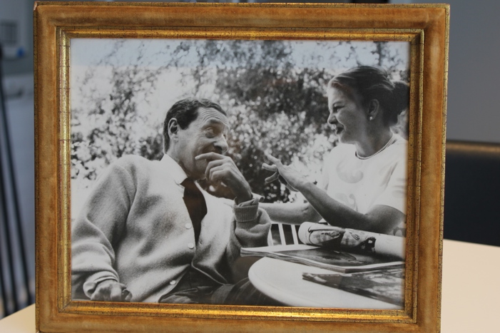 A framed photo of Harold Arlen with his hand on his face looking over at his smiling wife with a newspaper in front of them.