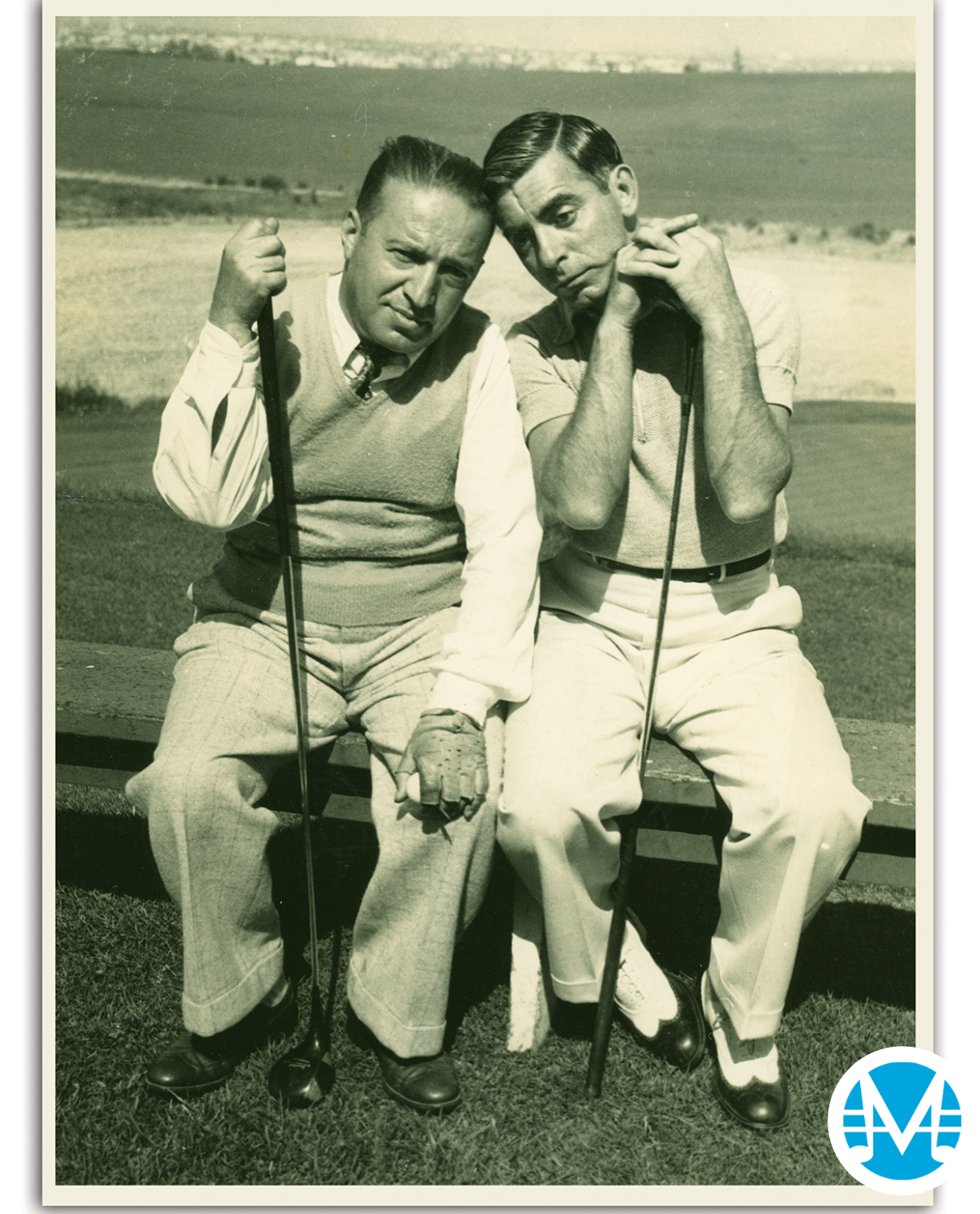 Gus Kahn and Eddit Canto pose with silly faces and hold golf clubs.